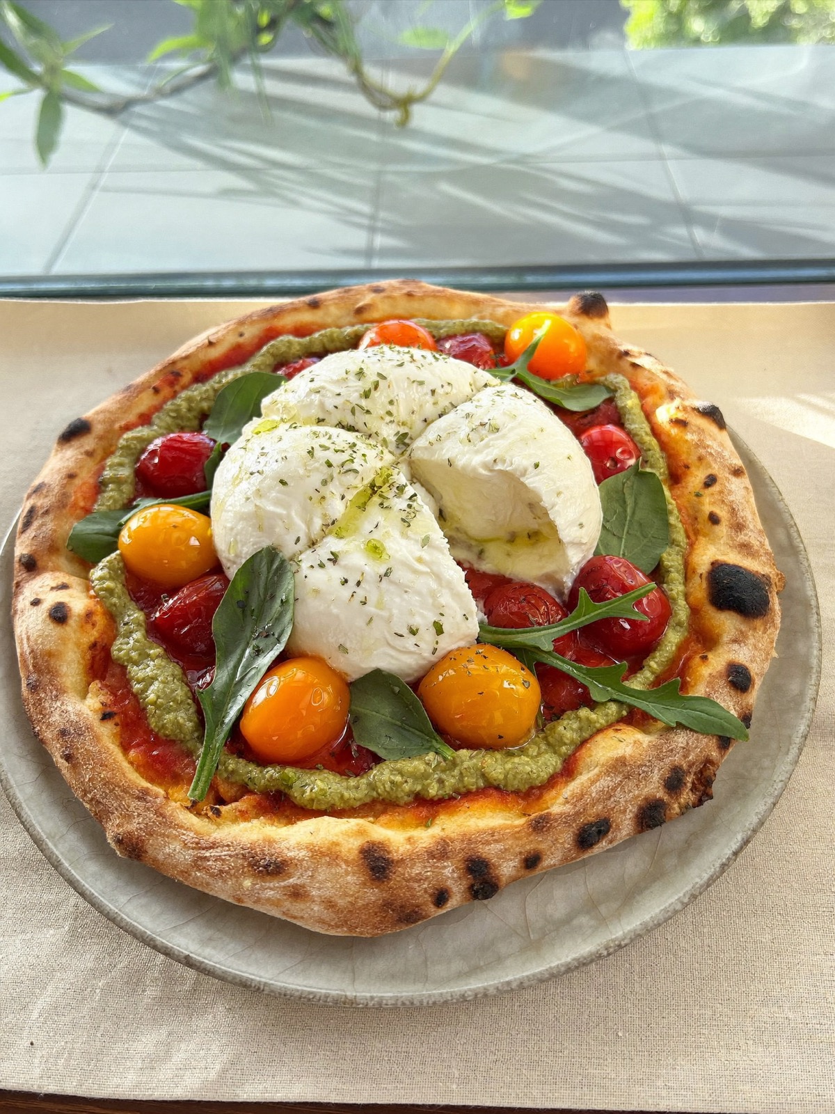 Pizza burrata entière ouverte sur tomates confites et pesto