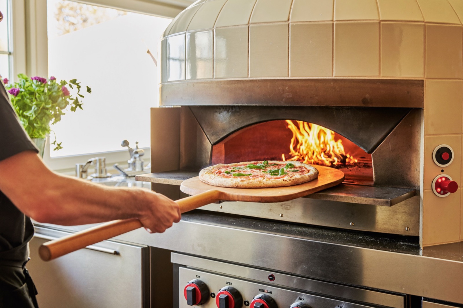 La pizza glissée au four à bois sur la pelle