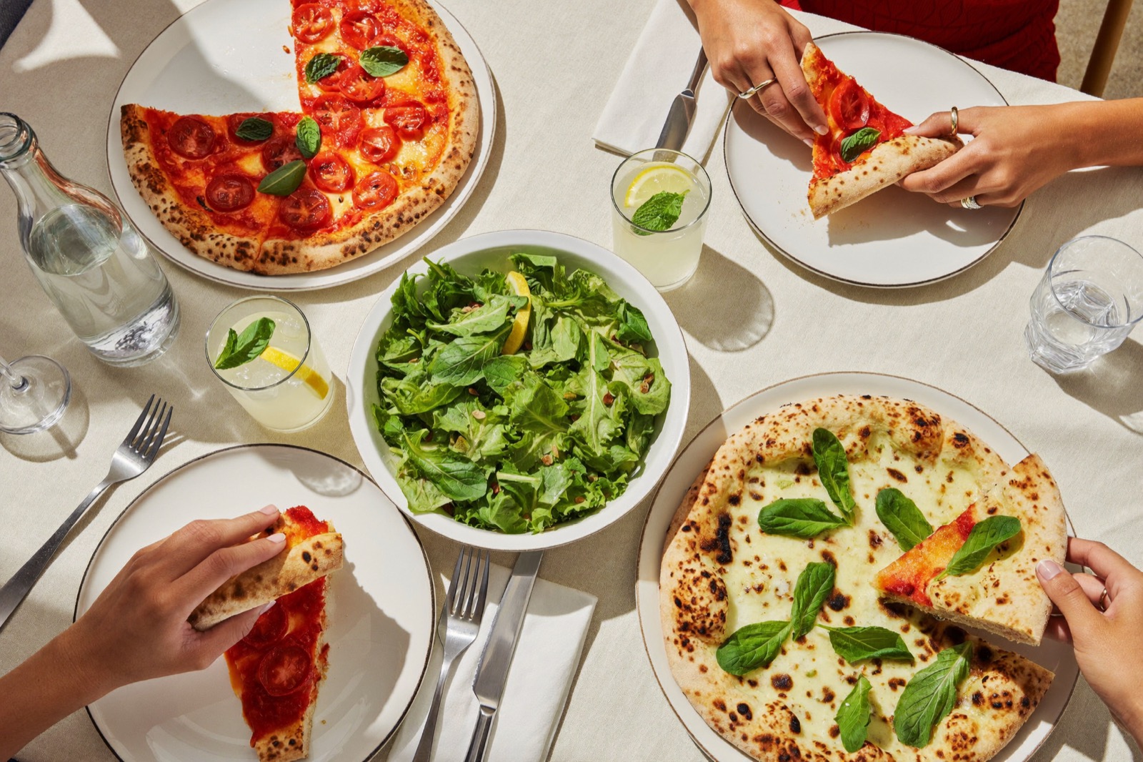 Table conviviale, pizzas et salade partagées